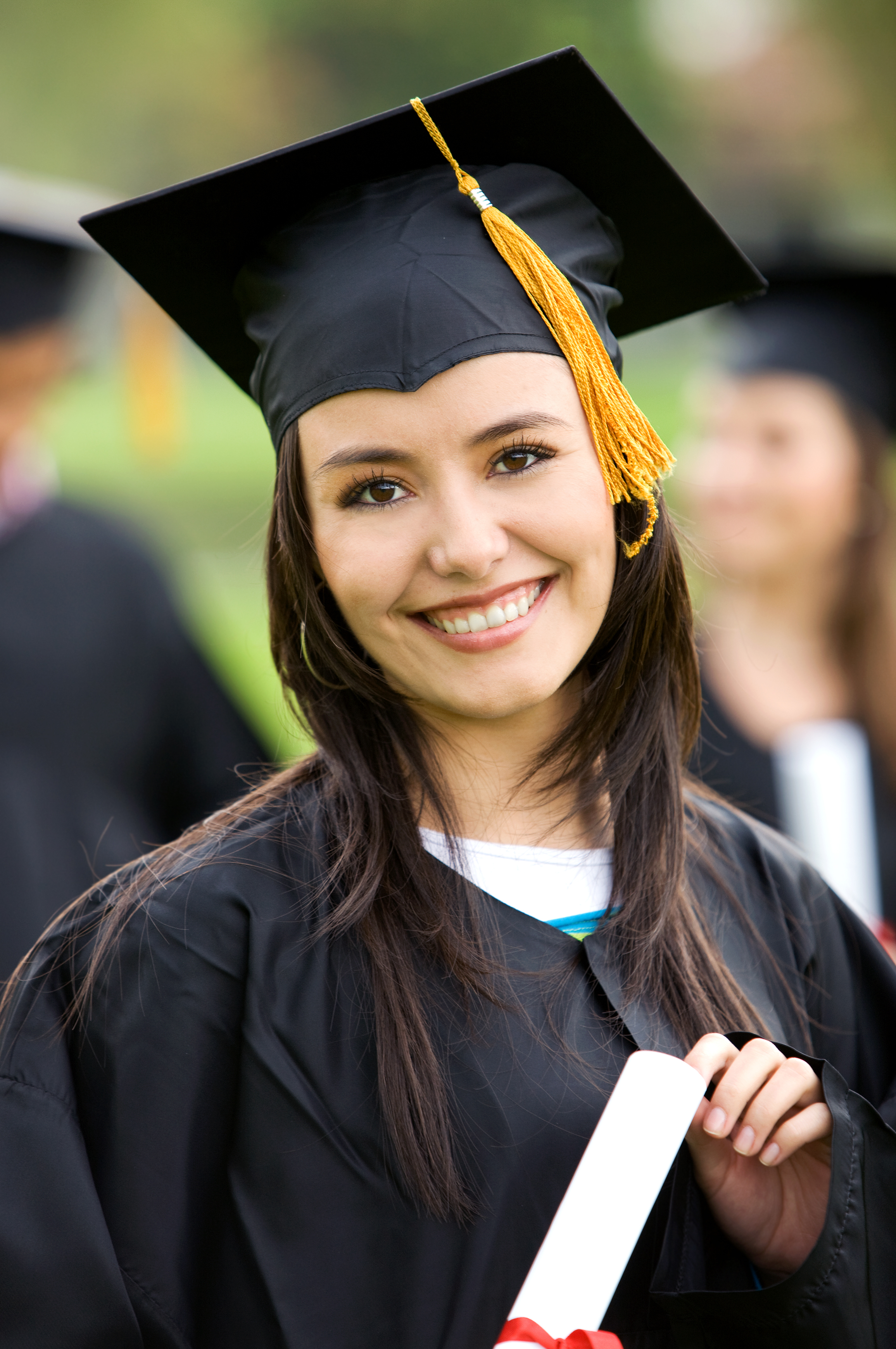 graduation woman portrait smiling and looking happy outdoors